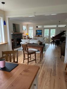 ein Wohnzimmer mit einem Tisch und einem Klavier in der Unterkunft Eaglenest Manor Cowichan in Duncan