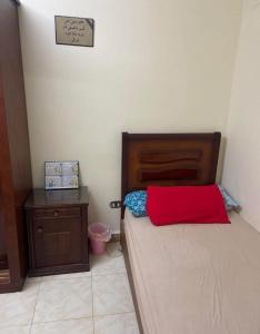 a bedroom with a bed with a red pillow on it at قرية هيلوبيتش الساحل الشمالي h in Dawwār Ibrāhīm Abū Shunaywīr