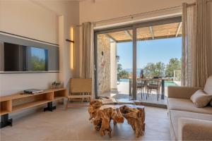 a living room with a couch and a table at Luxury Stone Villas Kefalonia in Trapezaki