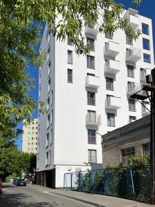 ein weißes Gebäude mit Balkon in einer Stadtstraße in der Unterkunft La Boutique Verte in Warschau