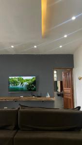 a living room with a couch and a flat screen tv at Casa em Paraty, piscina com vista para o mar in Paraty