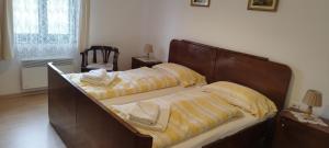 a bedroom with two beds and a chair at Várlak vendégház in Mórahalom