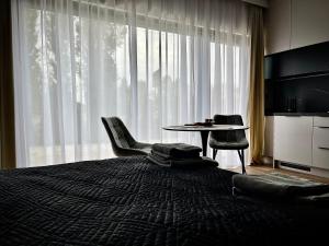 a bedroom with a bed with a table and chairs at Horizon Park Lux in Boszkowo