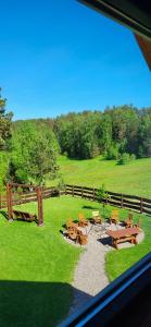 a view of a field with picnic tables and a fence at Domek w sercu Kaszub in Dziemiany +6 photos