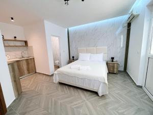 - une chambre avec un lit blanc et une salle de bains dans l'établissement Guest House Koliqi, à Ulcinj