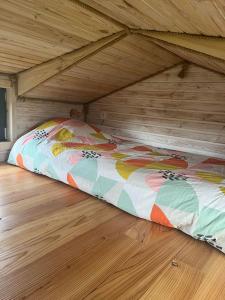 Cama en habitación con suelo de madera en Tiny House des couriols, en Montmeyran
