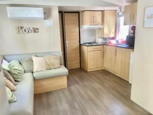 a small room with a couch and a kitchen at Tiny House, Mobilhome 6 personnes au Port de Vendres plage in Vendres