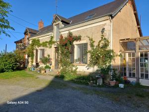 ein Haus mit Blumen auf der Seite in der Unterkunft Les Chaumes Violettes in Cluis