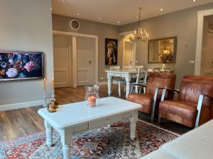 Van Doremaele Luxury Guesthouse في Velddriel: غرفة معيشة مع طاولة وكراسي بيضاء