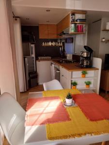 a small kitchen with a table with a yellow and red rug at Mobil home emplacement 38a in Les Mathes