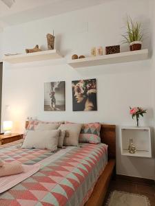 1 cama en un dormitorio con cuadros en la pared en Villa al vent (lujo & relax), en Benitachell