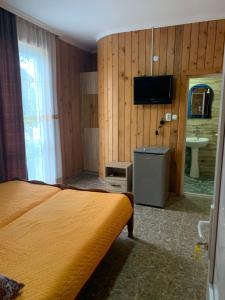 a bedroom with a bed and a sink and a television at UREKI MARI MARI in Ureki