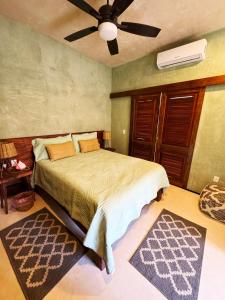 Casa vishami في كوزوميل: غرفة نوم بسرير ومروحة سقف