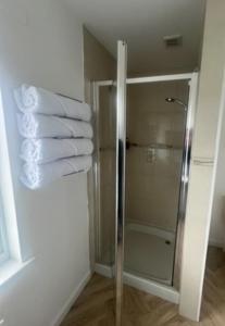 bagno con doccia e una pila di asciugamani di Eldon Lea a Strathpeffer