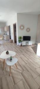 a living room with two tables and a television at Casa di Calma in Ermoupoli