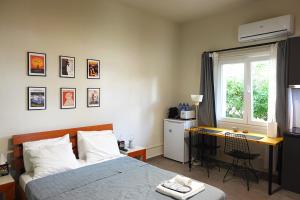 a bedroom with a bed and a desk and a window at Under the Palms in Nicosia