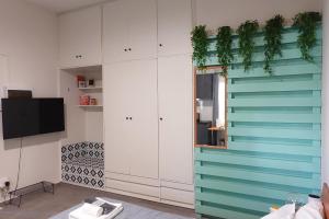 a living room with white cabinets and a tv at Under the Palms in Nicosia