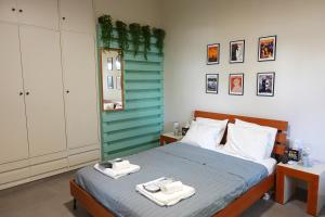 a bedroom with a bed with two towels on it at Under the Palms in Nicosia