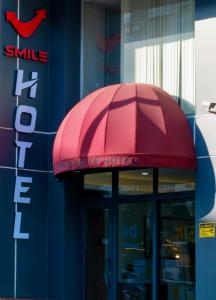 einen roten Regenschirm über dem Eingang eines Gebäudes in der Unterkunft Smile Suite Hotel in Çaycuma