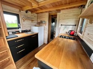 una cocina en una casa pequeña con paredes de madera en Tiny House des couriols, en Montmeyran