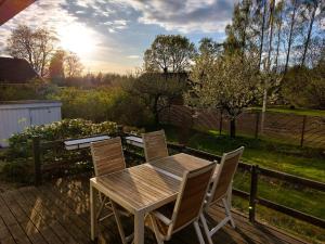 une table et des chaises en bois sur une terrasse dans l'établissement Vitahuset, 1 min Vallentuna Idrottsplats, à Vallentuna