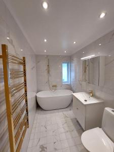 Un baño blanco con bañera y lavabo. en Vitahuset, 1 min Vallentuna Idrottsplats, en Vallentuna