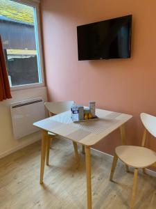 um quarto com uma mesa e uma televisão na parede em Au réconfort de Mers Draps et Serviettes fournies Appartement 12 em Mers-les-Bains