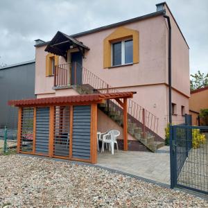 ein Haus mit einer Terrasse und einer Treppe davor in der Unterkunft Mieszkanie wakacyjno-pracownicze całoroczne 
