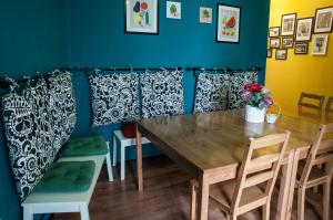 a dining room with a wooden table and chairs at Antique Hostel in Bucharest