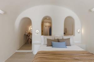 1 dormitorio con paredes blancas y 1 cama grande en Blue Art Caves, en Oia