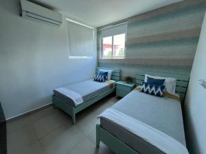 a bedroom with two beds and a couch and a window at Playa Blanca Beach Rentals in Playa Blanca