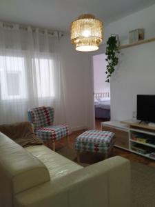 a living room with a couch and a chandelier at La cámara secreta de BelNi in Avilés