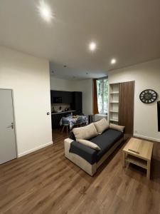 a living room with a couch and a table at Le Grand HELDER in Vichy