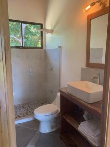 a bathroom with a white toilet and a sink at Casa Tres Tucanes in Barú