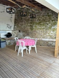 a table with two chairs and a pink table cloth at L'Hématite in Les Épesses