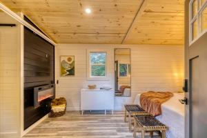 ein Schlafzimmer in einem winzigen Haus mit einem Bett und einem Kamin in der Unterkunft Couples Retreat: King Bed:Hot tub:Firepit & More in Blue Ridge