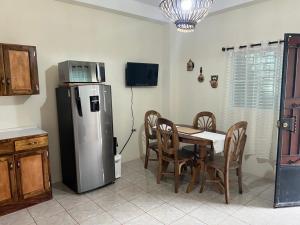 una cocina con mesa de comedor y refrigerador en Casita Luz, en Juayúa
