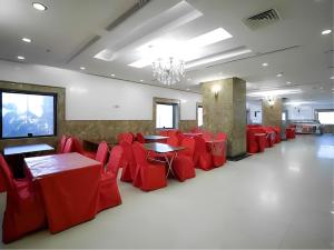 a banquet hall with red tables and chairs at Nasamaat Ajyad Hotel in Mecca
