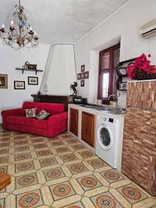 una cucina con divano rosso e lavatrice di Villa Strazzeri a Palermo
