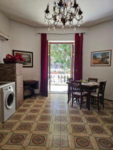 a dining room with a table and chairs and a chandelier at Villa Strazzeri in Palermo