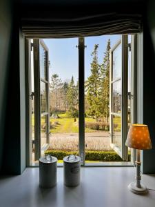 une lampe assise sur une table devant une fenêtre dans l'établissement Kleine Perle, à Brodersby