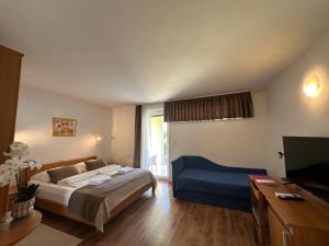 a bedroom with a bed and a blue couch at Garni Hotel Keltika in Izola +46 photos