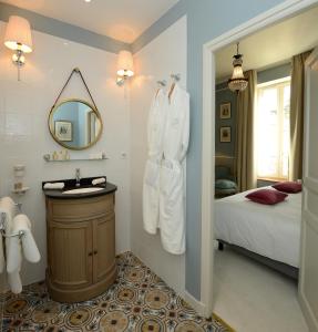 a bathroom with a sink and a bed and a mirror at Grand Hôtel Henri - Teritoria in LʼIsle-sur-la-Sorgue