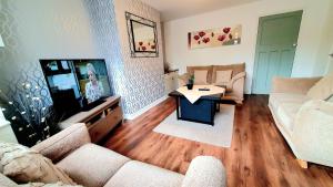 uma sala de estar com um sofá e uma televisão em Yucca cottage em Kendal