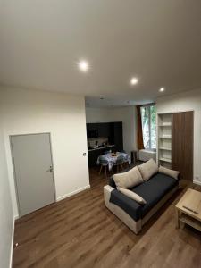 a living room with a couch and a table at Le Grand HELDER in Vichy