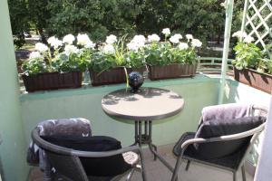 einen Tisch und zwei Stühle auf einem Balkon mit Blumen in der Unterkunft Szarotka II in Stettin