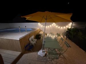 - une table avec un parasol à côté de la piscine dans l'établissement 4 minutes à pieds de la plage., au Conquet
