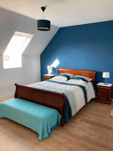 ein Schlafzimmer mit einem Bett und einer blauen Wand in der Unterkunft Maison non fumeur - jardin 5 personnes aux portes de Brest in Guipavas
