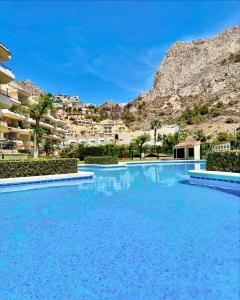 a large swimming pool with a mountain in the background at Can Luc Altea in Altea