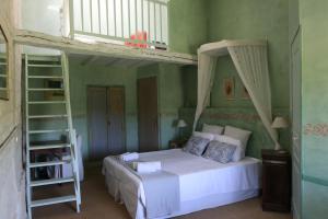 ein Schlafzimmer mit einem Bett und einem Hochbett in der Unterkunft Chambres d'hôtes du Noisillet in Cinais
